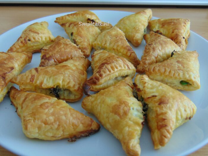 bord met bladerdeeghapjes met spinazie en boursin