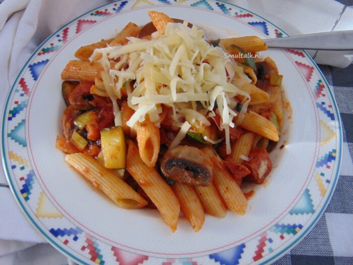 bord pasta met salami in tomatensaus van dichtbij