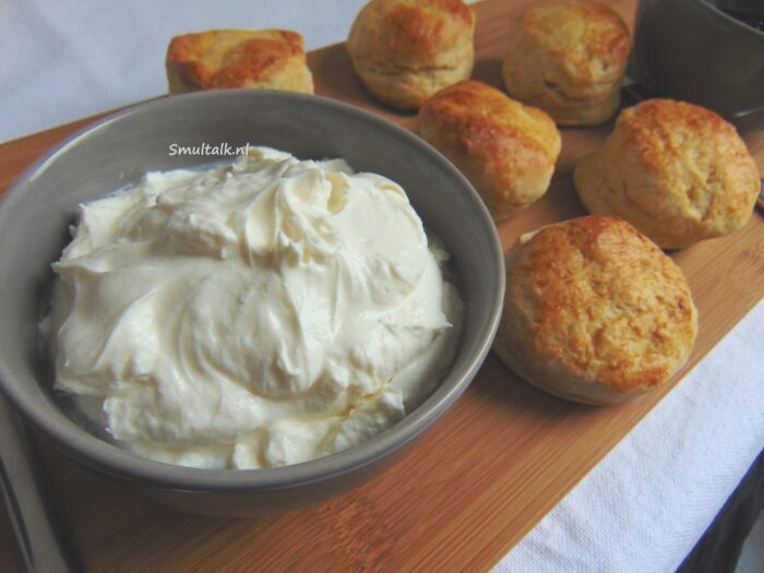 Schaaltje clotted cream met op achtergrond scones