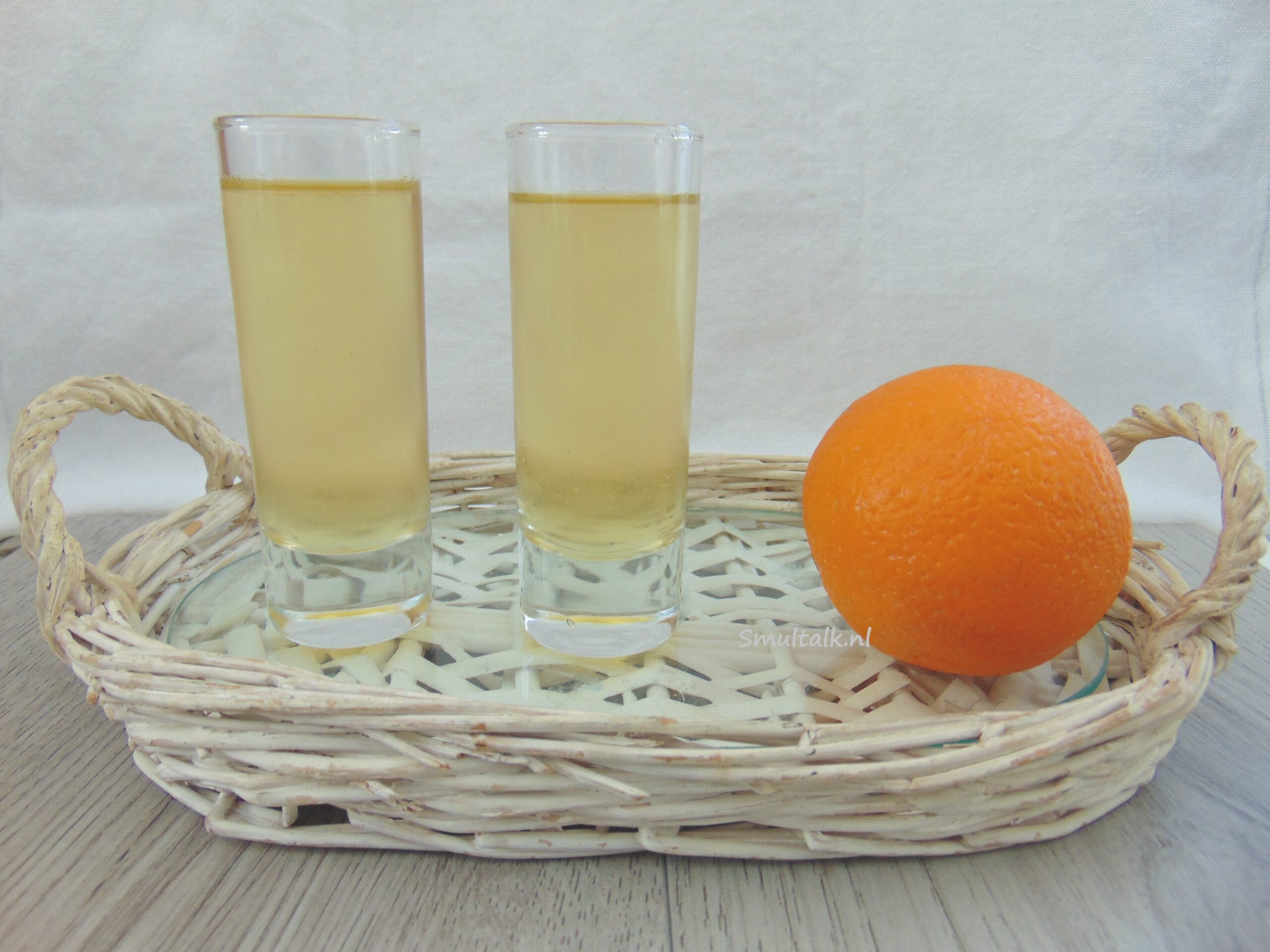 2 glaasjes arancello met een sinaasappel